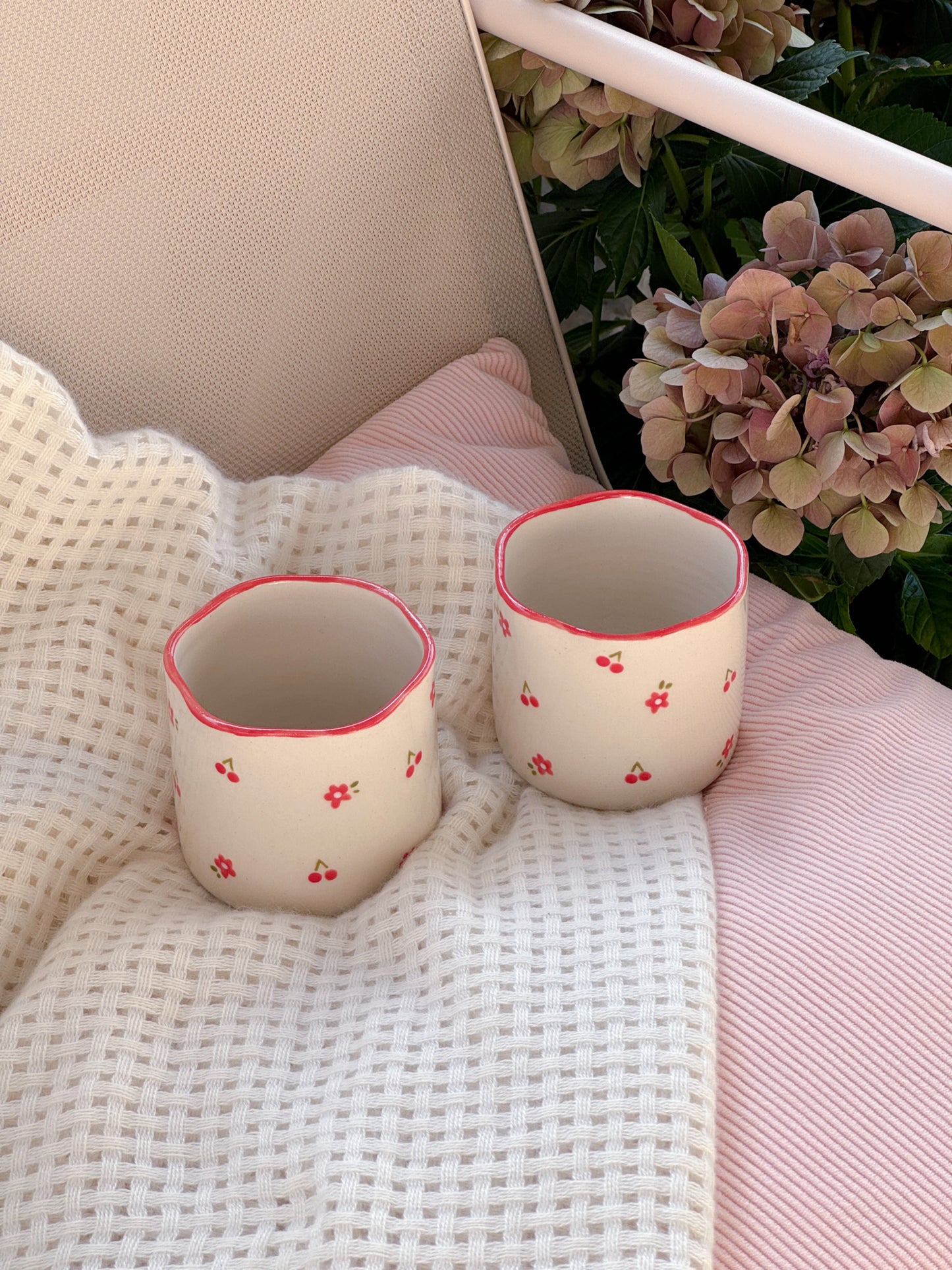 Cup with cherries and red flowers