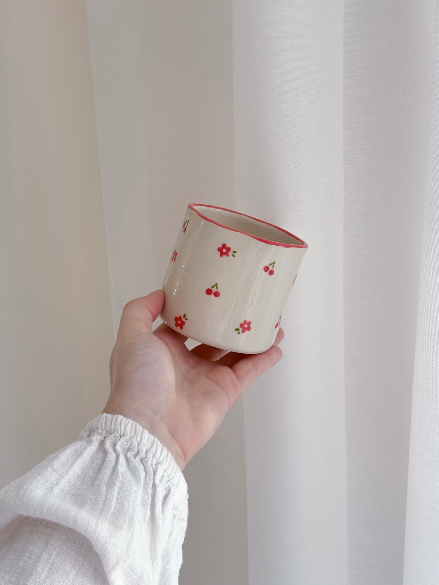 Cup with cherries and red flowers